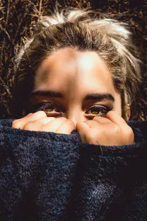 Woman hiding behind her shirt with C- PTSD symptoms. Are you ready to start Trauma therapy detroit?