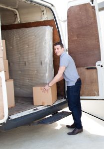 Man storing boxes in storage unit