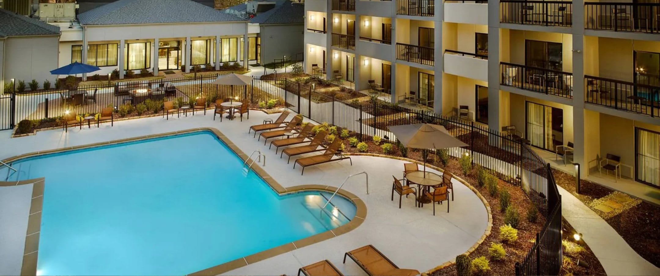 A unique hotel pool design adds a resort-like feel with surrounding loungers and umbrellas