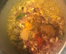 Add onions and spices to goat curry