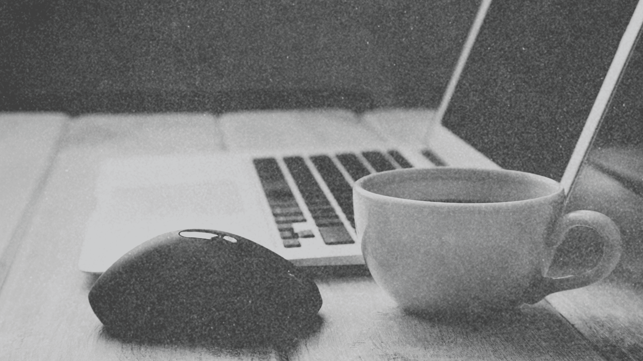 Organized desk with coffee and a computer, set up for a virtual All-Hands Meeting for events and reading blogs.