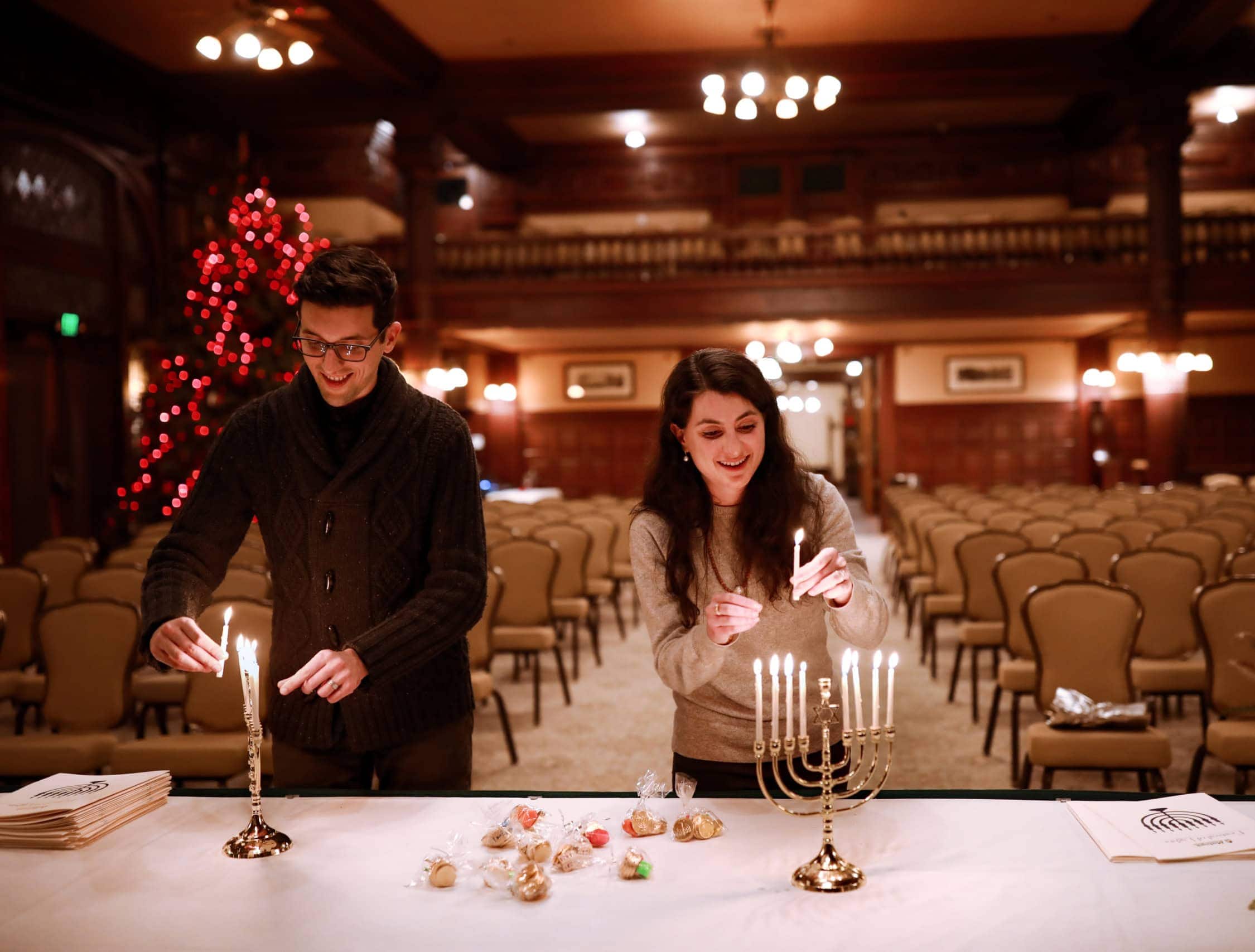 People Lighting the Candles of a Menorah
