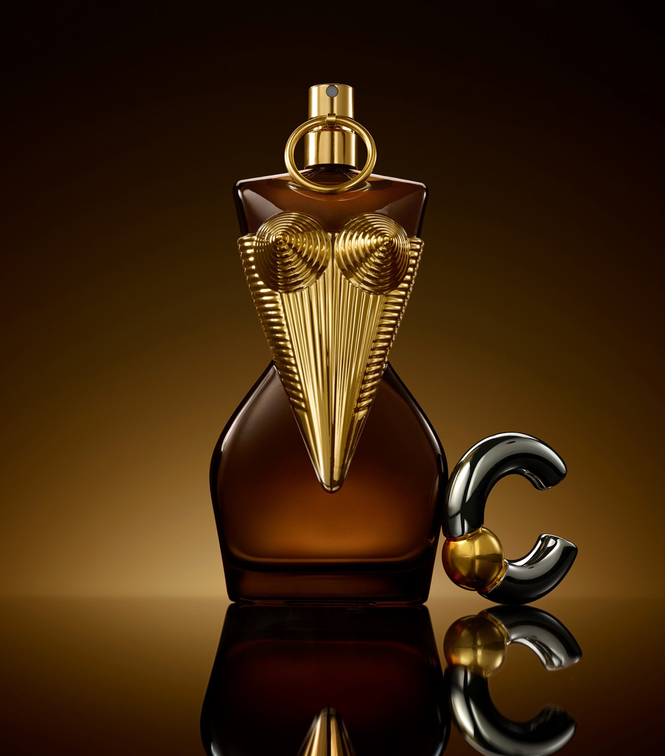 Jean Paul Gaultier Divine Elixir Parfum bottle with amber glass and gold corset design, symbolizing bold femininity and radiant fragrance notes