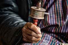 Hände mit Gebetsmühle in Bhutan