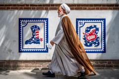 Ein Mullah schreitet vorbei an Propaganda-Graffitis