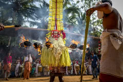 Theyyam-Gott mit Fackeln