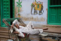 Rikscha-Fahrer macht Pause in Varanasi, Indien