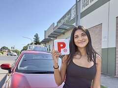 Successful driver holding P-plates following testing day verification with a dual-control car.