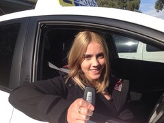 Successful driving student celebrating passing their practical driving test at the registry.