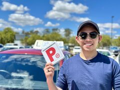 Successful D-Tech driving student celebrating passing their driving test at the registry.