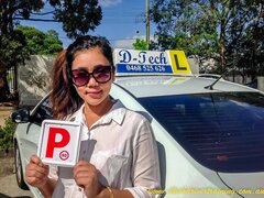Student Seng Htui smiling with her P-plate after passing her driving test.