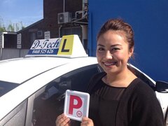 Student Shwe Hmone holding her red P-plate after passing her practical driving test in Blacktown.