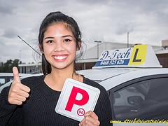 Student Monica giving a thumbs up with her red P-plate at D-Tech Driver Training Blacktown.