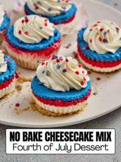 Individual layered red, white, and blue patriotic mini cheesecakes topped with whipped cream and sprinkles, featuring a text overlay that reads No Bake Cheesecake Mix Fourth of July Dessert.