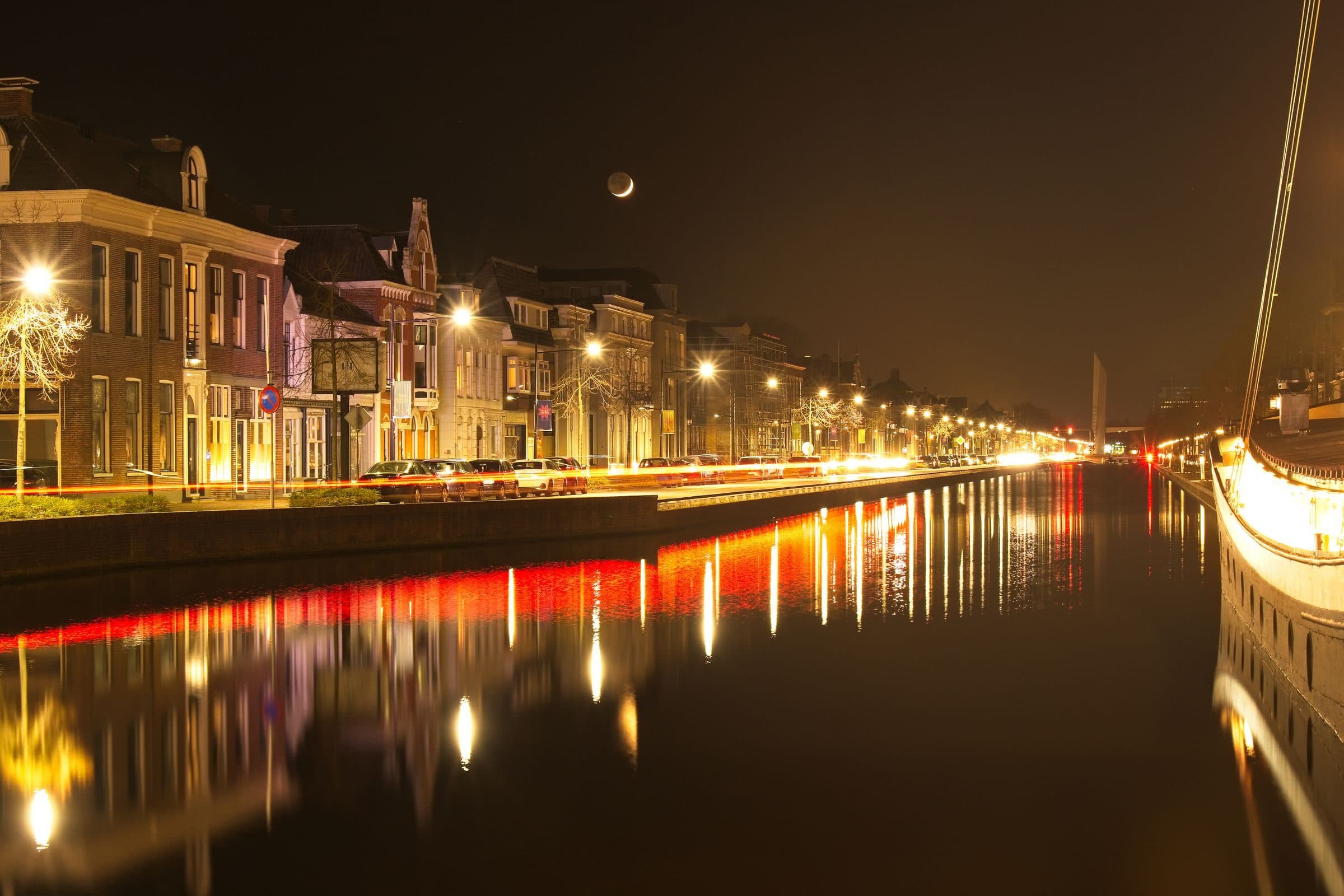 Gracht in Assen bij avond met verlichte gevels