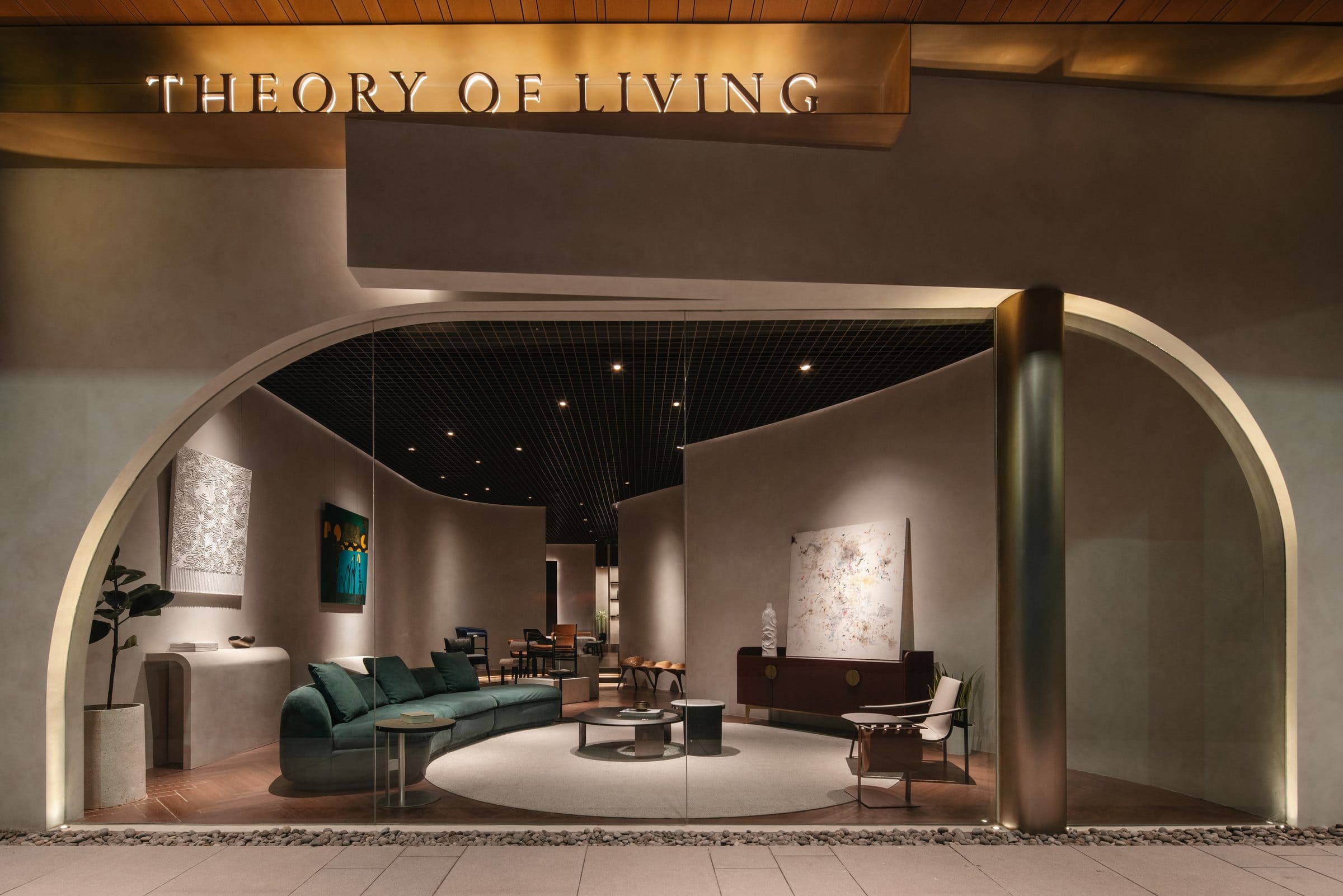 Theory of Living furniture showroom at Indonesia Design District, Jakarta — curved arch entrance with contemporary sofa, sideboard and art