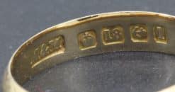 Close-up of gold ring hallmarks showing purity and maker's marks.