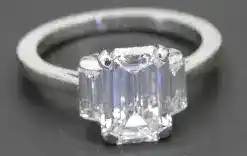 Elegant emerald-cut diamond ring with a sleek silver band, perfect for engagement or special occasio.