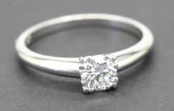 Diamond engagement ring with a square-cut center stone and a sleek silver band.