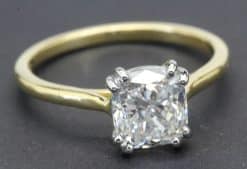 Engagement ring with a large cushion-cut diamond set in a gold band.