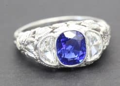 Stunning sapphire and diamond ring with intricate silver band design.