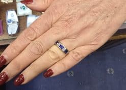 Close-up of a woman's hand wearing a sapphire and silver ring at Weldons Jewellers.