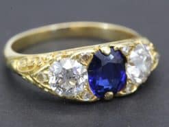 Elegant sapphire and diamond ring with gold band, perfect for special occasions.