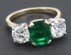 Elegant emerald and diamond ring with gold band.