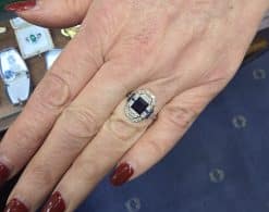 Elegant sapphire and diamond ring on a woman's finger, showcasing fine jewelry craftsmanship.