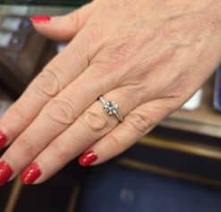 Engagement ring with a sparkling diamond on a woman's hand.