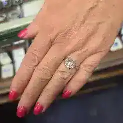 Emerald cut diamond ring on a woman's finger, showcasing fine jewelry craftsmanship.