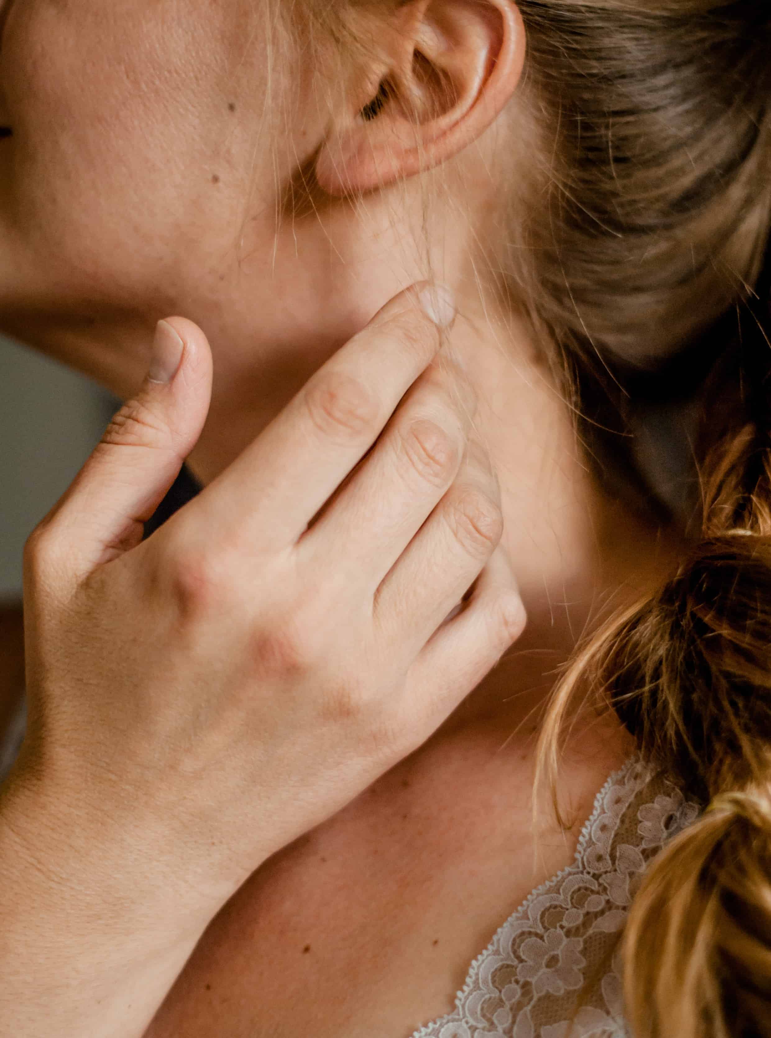 Woman touching her neck. Nutrients for Under active Thyroid