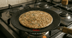 Golden brown egg paratha flipped on tawa showing crispy cooked side