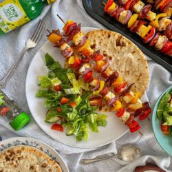 served skewers with bread and salad.