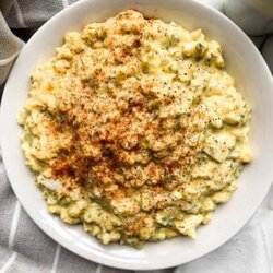 top view of healthy egg salad in a white bowl next to a dish towel