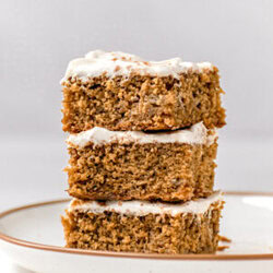 three sqaures of gluten free banana cake with cream cheese icing on top