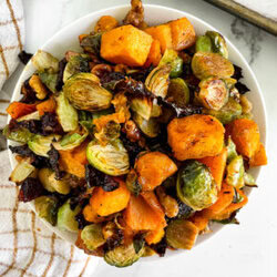 top view of fall roasted veggies in a white bowl next to a towel
