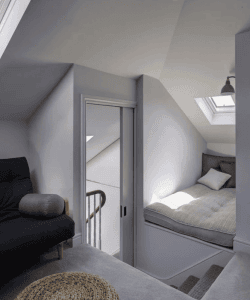 Cozy attic bedroom with skylight, minimalist decor, and plush bedding, ideal for relaxation and restful sleep in a serene home setting.