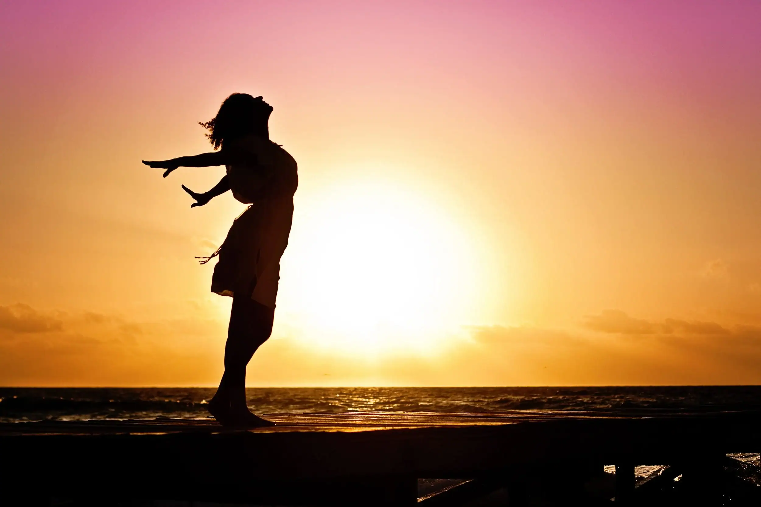 Woman in nature with her arms in the air. Somatic therapy near me.