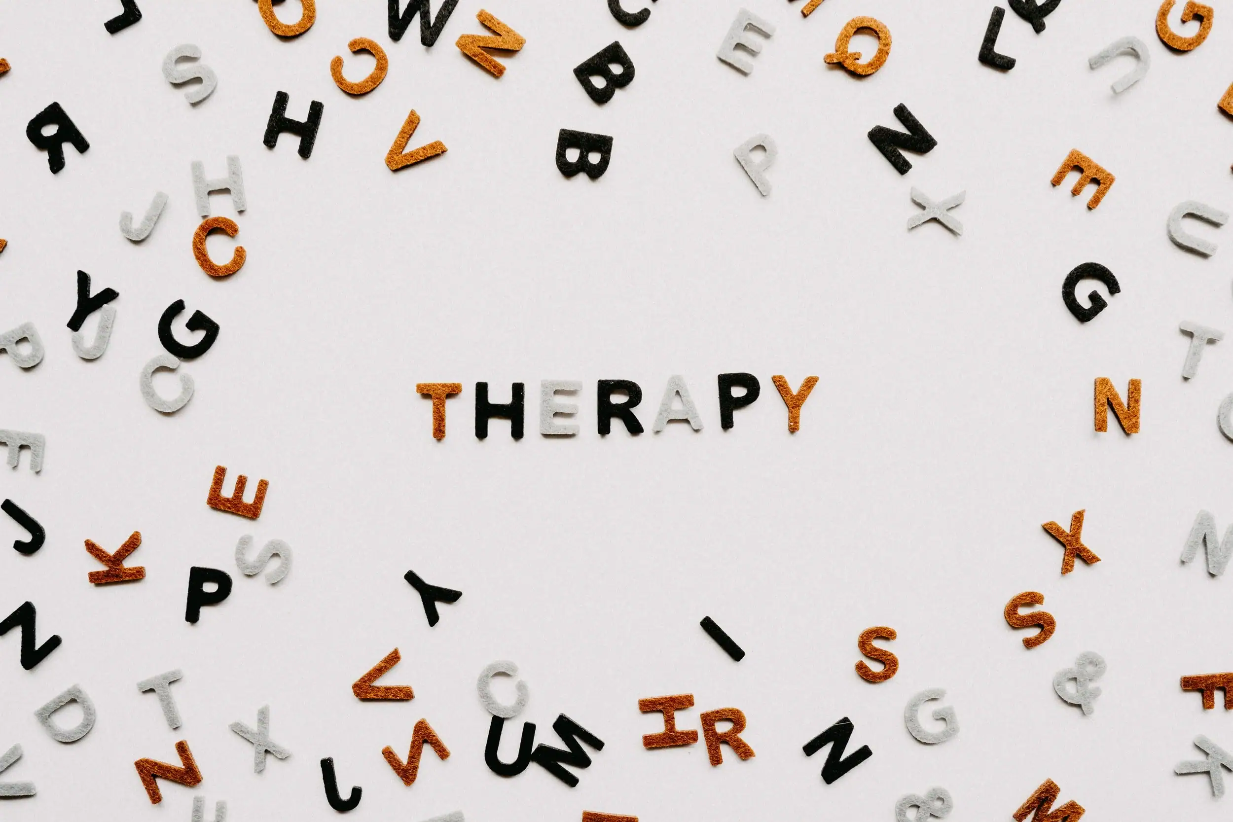Scattered letter tiles surround the word THERAPY in the center, suggesting language or speech therapy themes. start online therapy michigan.