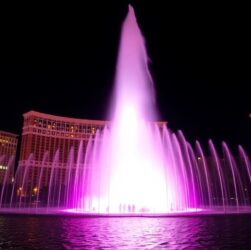 Water sprays high from fountain at night
