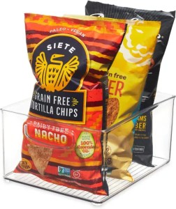 Vegan grain-free tortilla chips and plant-based snacks in colorful packaging on a clear wire basket, emphasizing healthy, allergen-free, and paleo-friendly options for gluten-free, dairy-free diets.