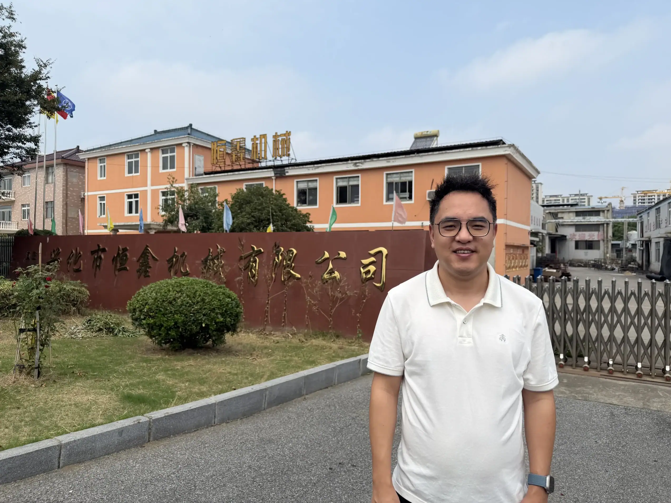 Person standing outside the factory entrance with the manufacturing building in the background
