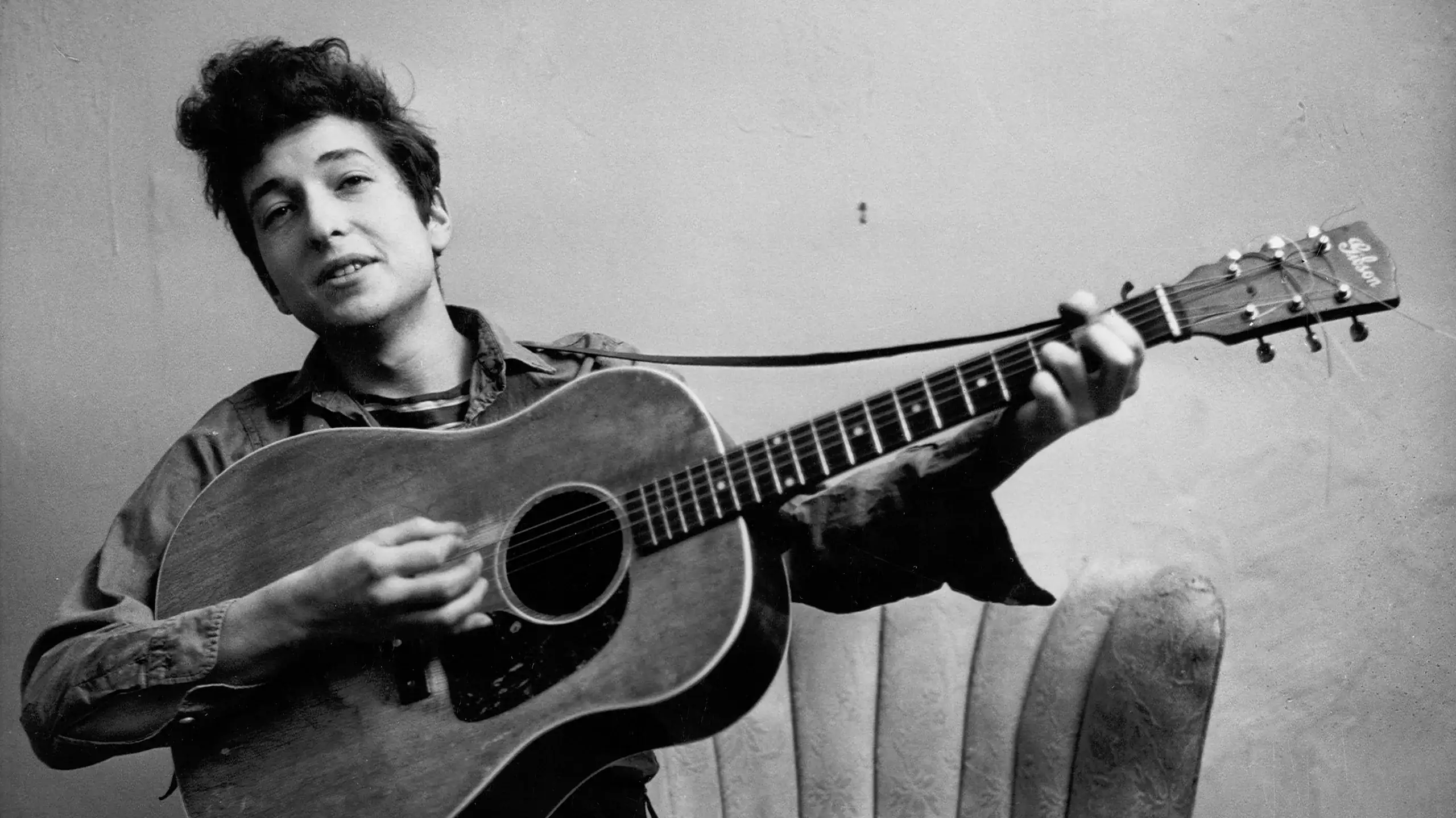 Bob Dylan sur scène, guitare à la main, lumière rasante, ambiance électrique, années 2020