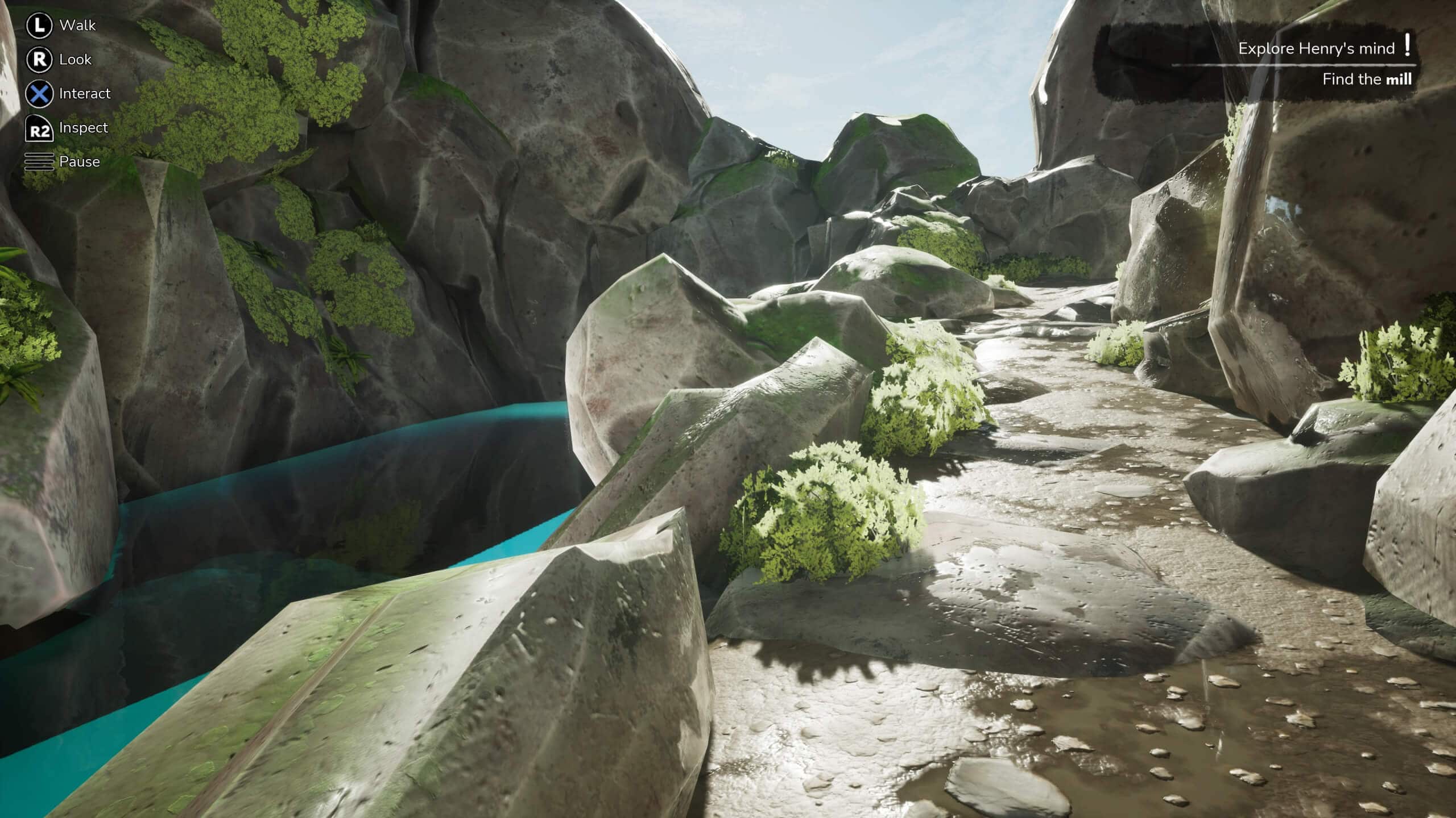 A rocky path leads up winds up a hill with large rocks on either side. There is a deep river with to the right of the screen.