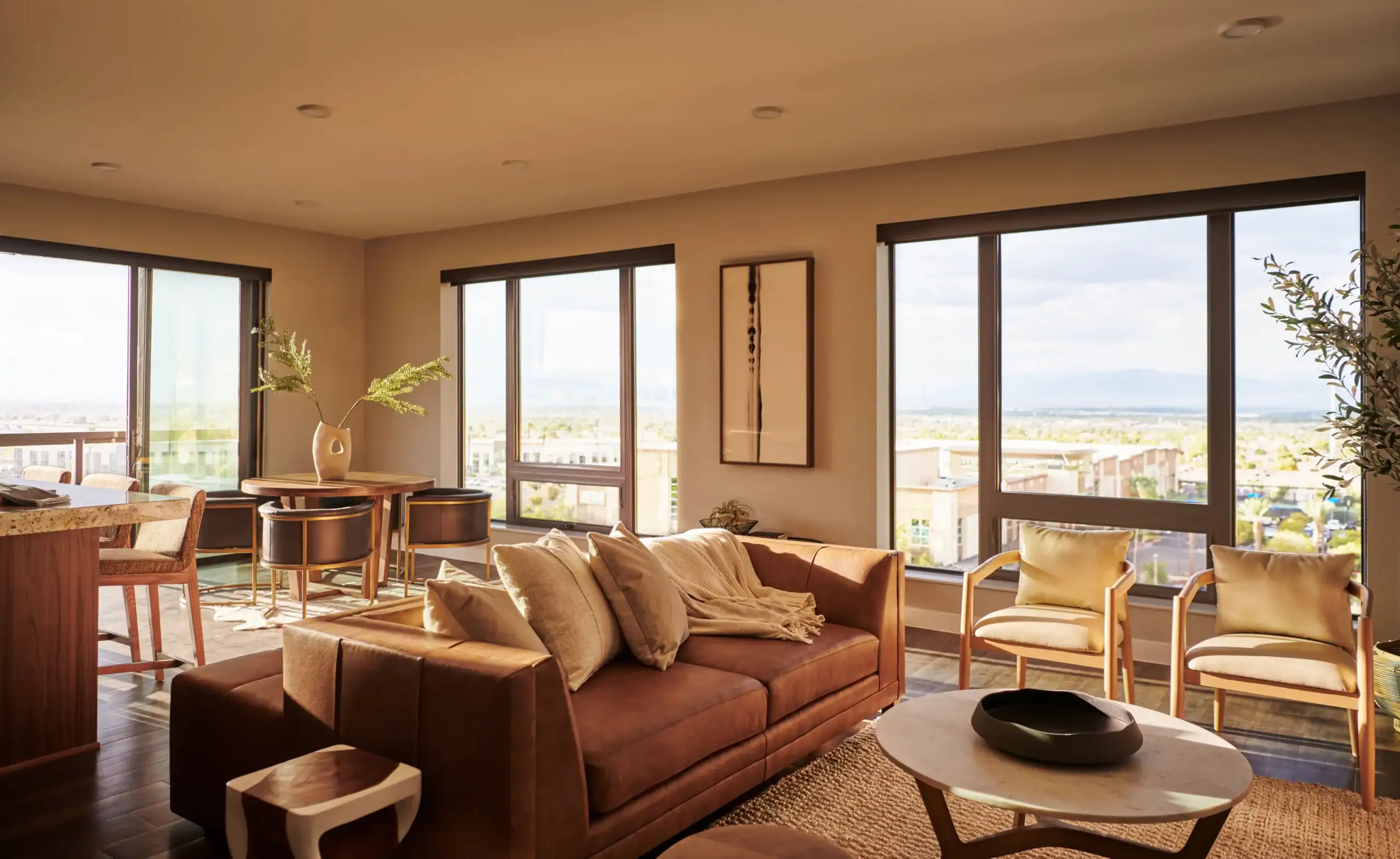 Modern open-concept apartment living room with leather sofa, dining area, floor-to-ceiling windows, and expansive city views.