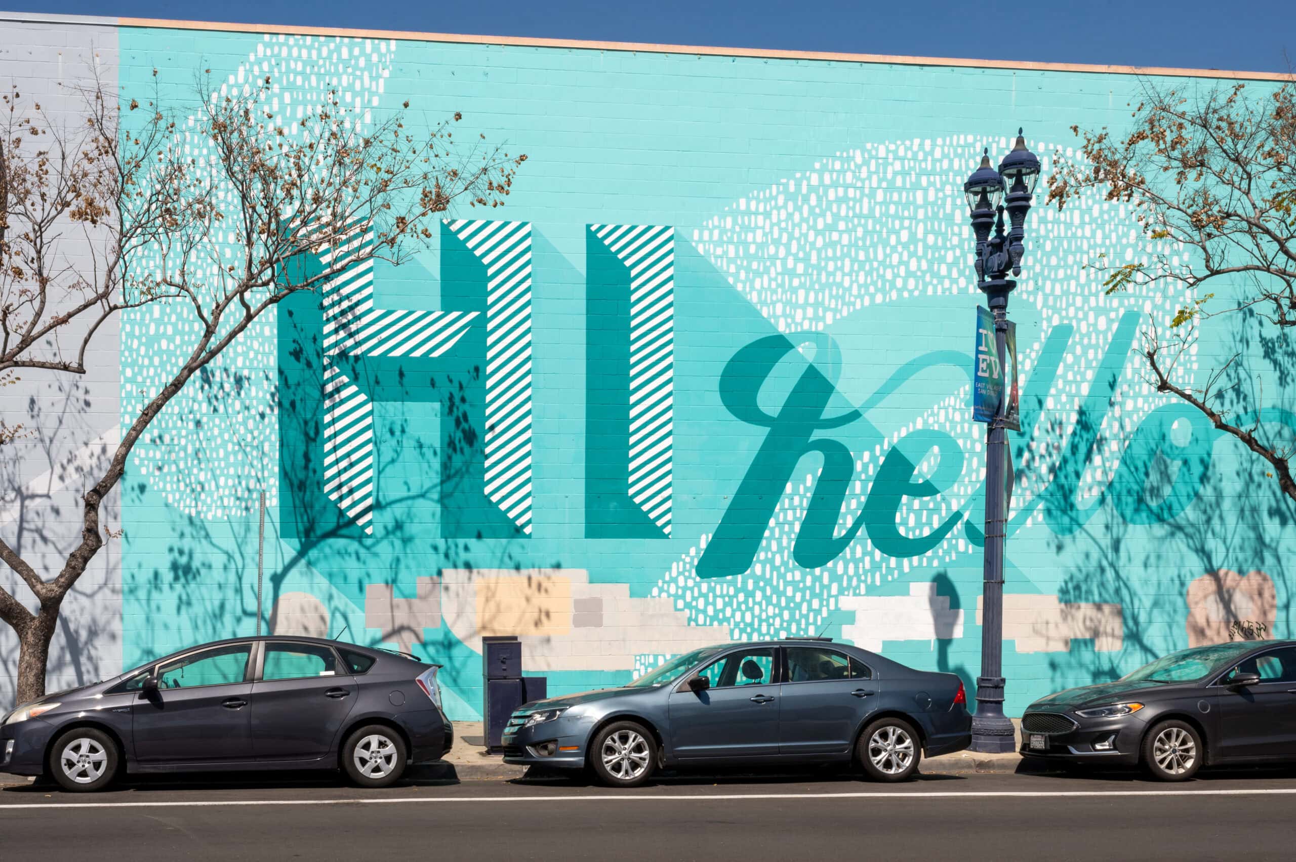 A street area with parked cars and a mural near The Wyatt apartments near Petco Park.