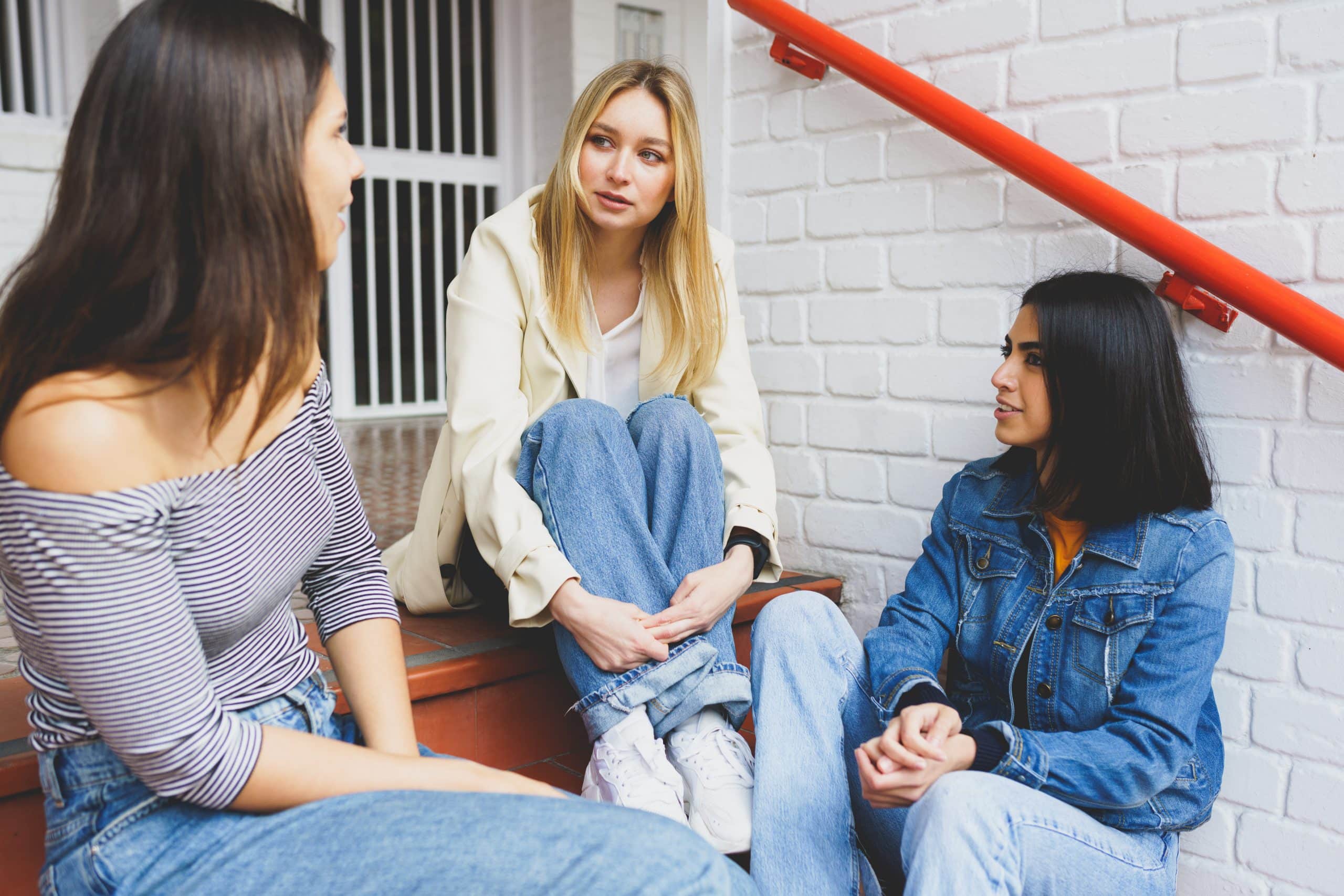 vecteezy multi ethnic group of three friends sitting on street steps 4833735 scaled