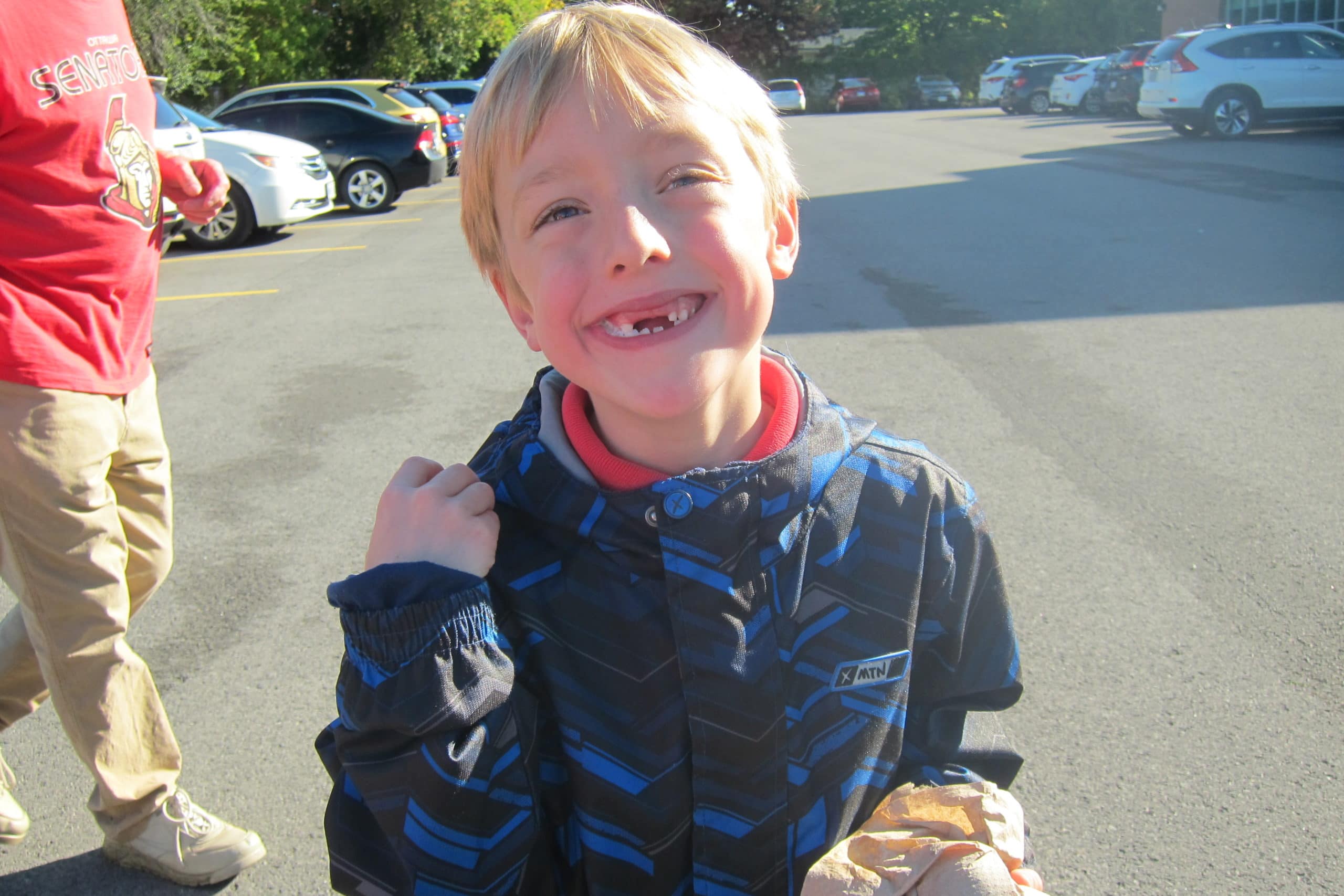 A boy with his front teeth missing with a big smile | Bishop Hamilton Montessori School in Ottawa