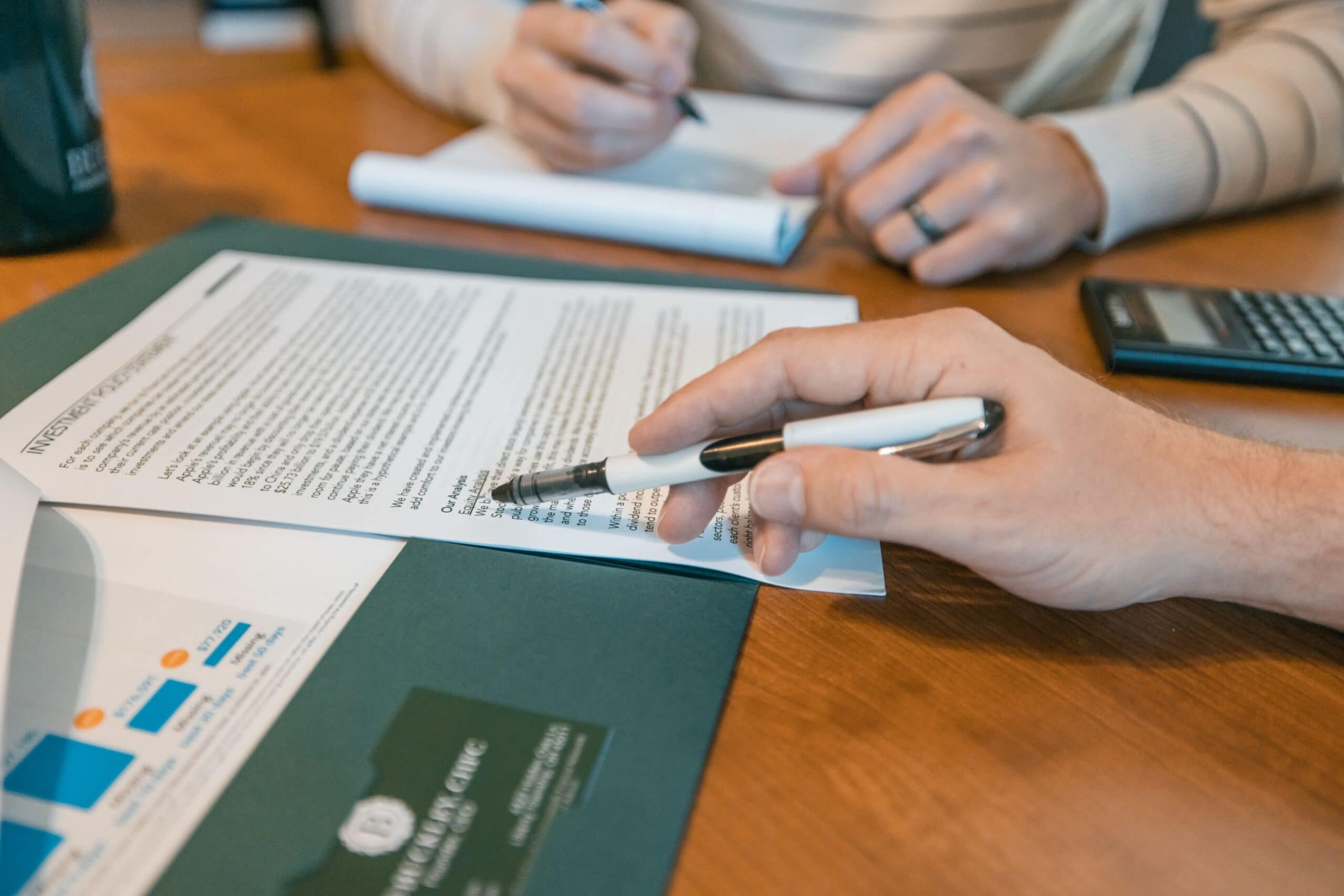 people reviewing plan at table with paper and hands